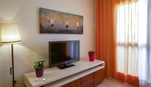 a living room with a flat screen tv on a cabinet at Leo Punta Umbría in Punta Umbría