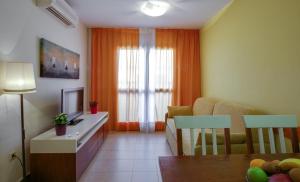 a living room with a couch and a table with a television at Leo Punta Umbría in Punta Umbría