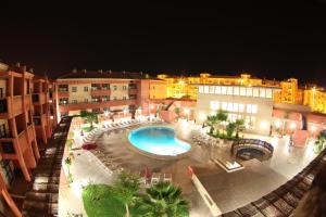an outdoor swimming pool in a city at night at Leo Punta Umbría in Punta Umbría