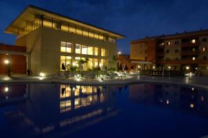 a building with a swimming pool at night at Leo Punta Umbría in Punta Umbría