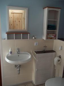 uma casa de banho com um lavatório e um WC em InselGlück em Fehmarn