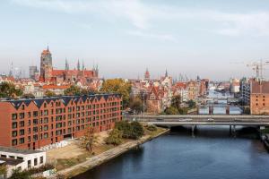 a city with a river and a bridge and buildings at Apartament Przystań w Waterlane Island in Gdańsk