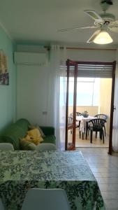 Habitación con cama y sala de estar con mesa. en Alba Apartment, en Laigueglia