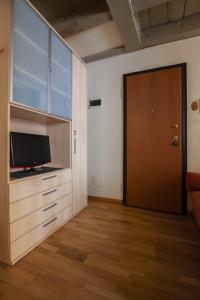 a living room with a tv and a wooden floor at Venice Apartment in Venice