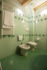 a green bathroom with a toilet and a sink at Venice Apartment in Venice