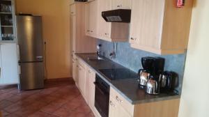 eine Küche mit Holzschränken und einem Kühlschrank aus Edelstahl in der Unterkunft Zellerhof in Finkenberg