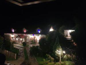 una casa illuminata di notte con luci viola di Agroturystyka Karczma nad Jarem Mierzejewo a Mierzejewo