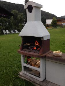 un horno de pizza con fuego en un patio en Haus Cosso, en Villabassa