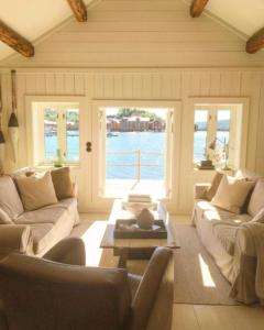 a living room with couches and a view of the water at The Boathouse in Råkvåg