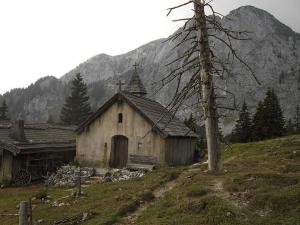 Eine alte Kirche auf einem Hügel in der Unterkunft Landhotel zum Staffelwirt in Jachenau