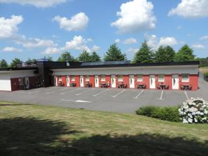 a large parking lot in front of a building at Hotel No Minoé in Locminé