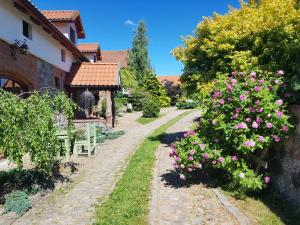 un jardín con flores rosas y una casa en Agroturystyka Karczma nad Jarem Mierzejewo en Mierzejewo