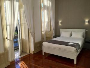 a bedroom with a white bed with white pillows at Hotel Jardim in Coimbra
