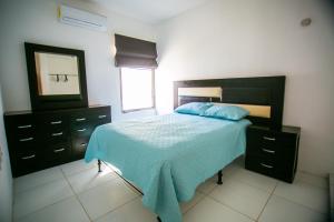 um quarto com uma cama com um espelho e uma cómoda em Casa moderna en segura Residencial Hacienda Chetumal em Chetumal