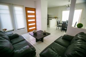 uma sala de estar com um sofá de couro e uma mesa em Casa moderna en segura Residencial Hacienda Chetumal em Chetumal