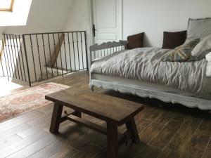 a bedroom with a bed and a coffee table at Maison de Sandrine in Jumeauville