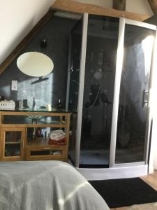 um quarto com uma grande janela de vidro e uma cama em Maison de Sandrine em Jumeauville