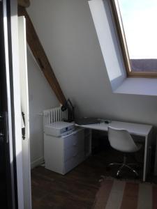 um quarto no sótão com uma secretária e uma janela em Maison de Sandrine em Jumeauville