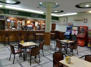 un restaurante con mesas y sillas y un bar en Hostal Don Pepe, en La Albuera