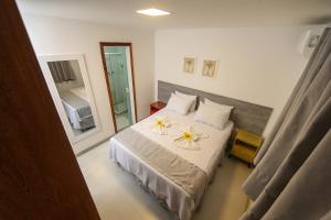 a bedroom with a bed with two flowers on it at Pousada Ravenalas - Apartamentos e Flats in Barra Grande