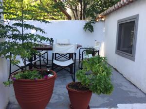 a patio with a table and two potted plants at Traditional Detached House in Spetses