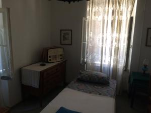a bedroom with two beds and a dresser and a window at Traditional Detached House in Spetses