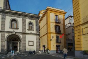een geel gebouw in het midden van twee gebouwen bij La Casa di Vittoria Sorrento in Sorrento