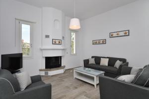 a living room with two couches and a fireplace at Nisides Villa Naoussa in Naousa