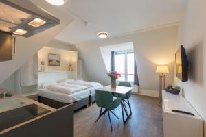 een hotelkamer met een bed, een tafel en een keuken bij Welcome in - Aparthotel Zoutelande Luxe Studio 2 personen - 1 huisdier toegestaan in Zoutelande