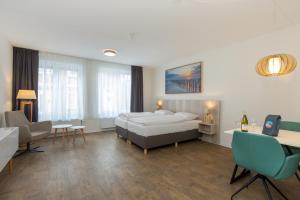 een hotelkamer met een bed, een bureau en stoelen bij Welcome in - Aparthotel Zoutelande Luxe Studio 2 personen - 1 huisdier toegestaan in Zoutelande