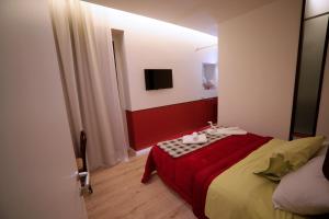 a bedroom with a bed with a red and white blanket at B&B IL GROTTINO in Modugno