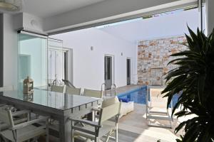 a dining room with a glass table and chairs at Nisides Villa Naoussa in Naousa