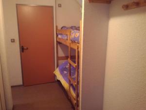 a room with two bunk beds and a door at les goutilles in Sainte-Marie-de-Campan