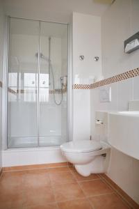 a white bathroom with a shower and a toilet at Bed&Breakfast Erber in Ismaning