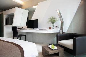 1 dormitorio con cama, silla y escritorio en Nine Forty One Hotel, en Bangkok