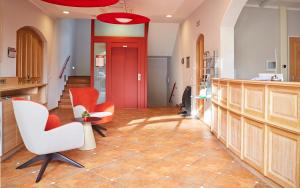 a hallway with orange chairs and a red door at Bed&Breakfast Erber in Ismaning