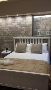 a large bed in a room with a brick wall at VENTIMIGLIA SUITE & WINE in Catania