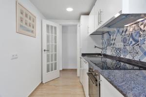 a kitchen with blue and white tiles on the wall at Pis Ocata in El Masnou