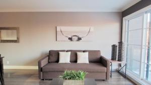 una sala de estar con un sofá con cuernos en la pared en INITIAL - CAVALIER - Chutes-Montmorency, en Boischâtel