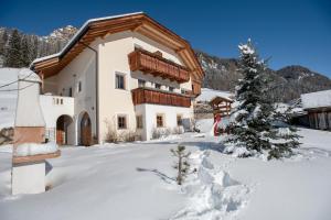 Una casa en la nieve con un árbol de Navidad en Apartment Fedares, en La Valle