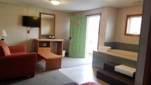 a bathroom with a green door and a tub at Milwaukie Inn Portland South in Milwaukie