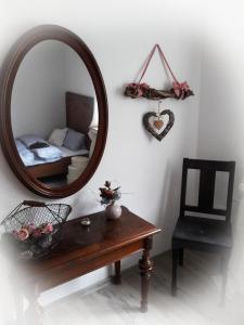 un espejo en una pared con una mesa y una silla en Fewo Froschkönig, en Schieder-Schwalenberg