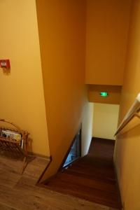 una escalera en una habitación con paredes amarillas y suelo de madera en Gîte des Grands Causses, en Millau