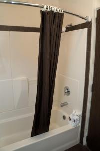 a bathroom with a shower curtain and a bath tub at California Inn Barstow in Barstow