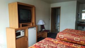 a hotel room with a bed and a television at Milwaukie Inn Portland South in Milwaukie