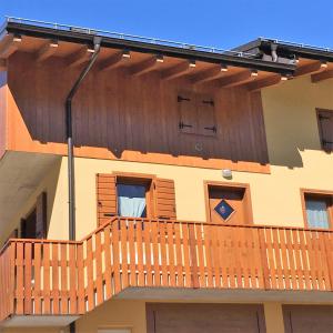 uma casa com um deque de madeira ao lado em Civetta em San Tomaso