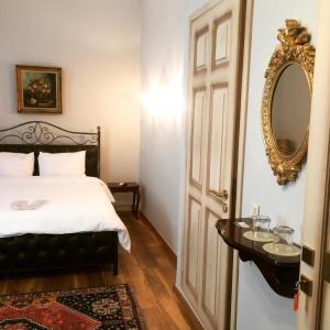 ヴェリアにあるLe Bijou Luxury Rooms & Suitesのベッドルーム1室(ベッド1台、壁掛け鏡付)