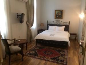 a bedroom with a bed and a chair and a table at Le Bijou Luxury Rooms & Suites in Veria