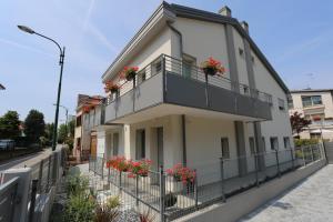 a white building with flowers on the balcony at DB Apartments - Dabasso in Mestre