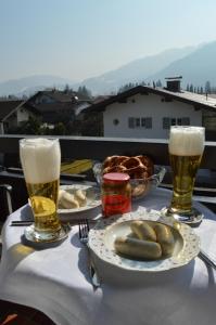 a table with two glasses of beer and plates of food at Yeti Lux - Panoramic Loft in Garmisch-Partenkirchen